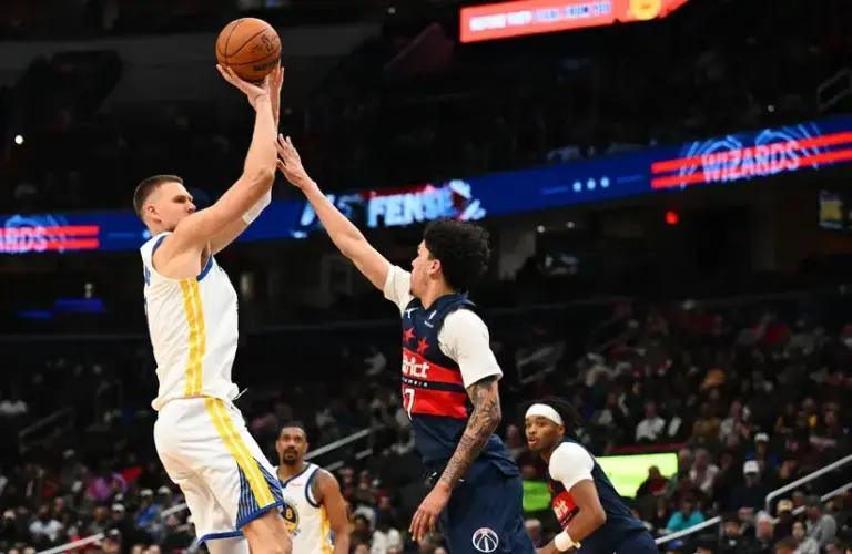 Golden State Warriors center Kristaps Porzingis (7) shoots over Washington Wizards guard Will Riley (27).