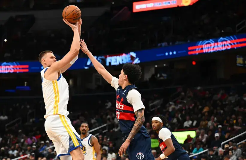 Golden State Warriors center Kristaps Porzingis (7) shoots over Washington Wizards guard Will Riley (27).