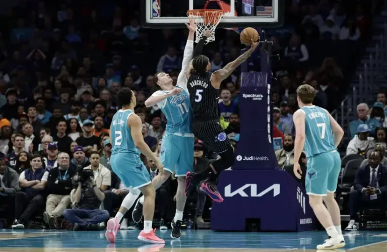 Orlando Magic forward Paolo Banchero (5) drives to the basket past Charlotte Hornets center Ryan Kalkbrenner (11)