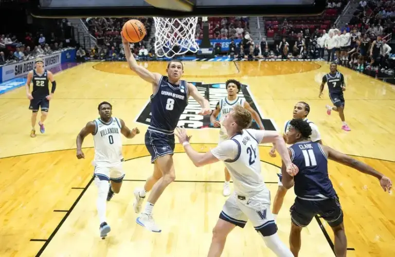 Utah State Aggies guard Drake Allen (8) dunks against Villanova Wildcats forward Duke Brennan (24) in the first half during a first round game of the men's 2026 NCAA Tournament.