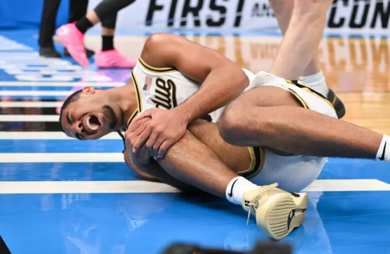 Purdue guard CJ Cox laying on the floor in pain during the second half of the NCAA Tournament.