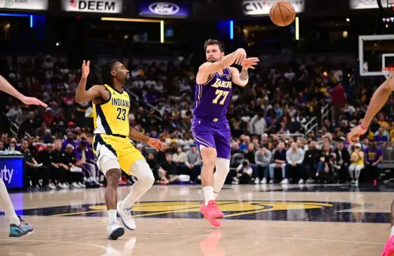 Los Angeles Lakers guard Luka Doncic (77) passes the ball away from Indiana Pacers guard Aaron Nesmith (23) during the second half.