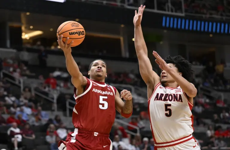 Arizona player attempts a block on a Arkansas player during NCAA Tournament.