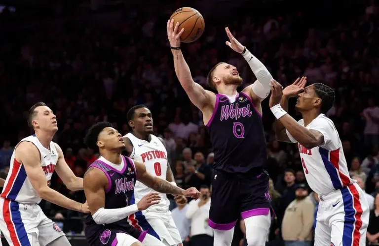Minnesota Timberwolves guard Donte DiVincenzo (0) shoots the ball as Detroit Pistons guard Ausar Thompson (9) defends.