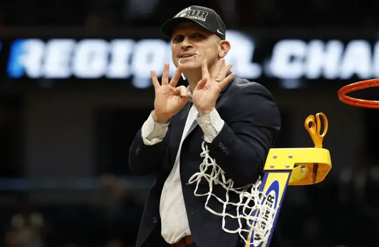 UConn Huskies head coach Dan Hurley celebrates after cutting down the net.