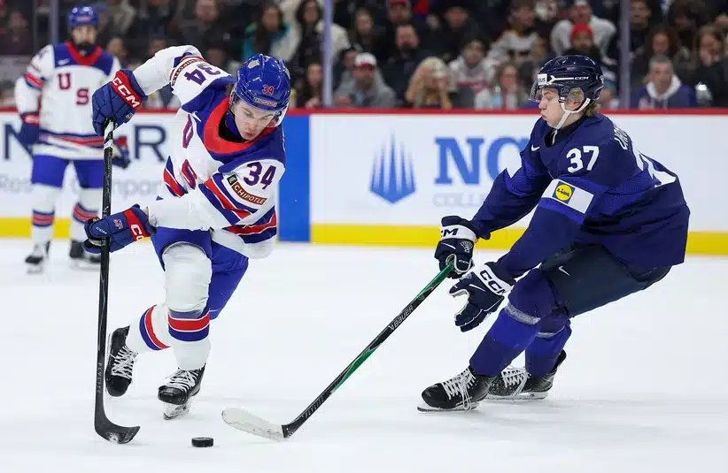 Jan 2, 2026; St. Paul, Minnesota, UNITED STATES; United States forward Cole Eiserman (34) and Finland forward Matias Vanhanen (37) compete for the puck during the first period in the quarterfinals of the 2026 IIHF World Junior Championship at Grand Casino Arena.
