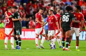 Liverpool and Manchester United players shake hands following their match.