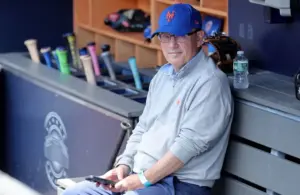 New York Mets owner Steve Cohen sits in the dugout.