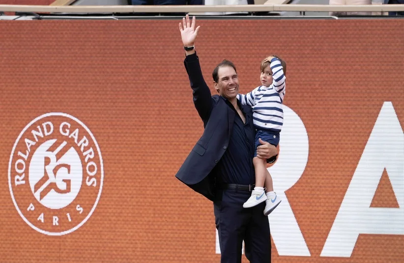 Rafael Nadal waving to the fans with his son