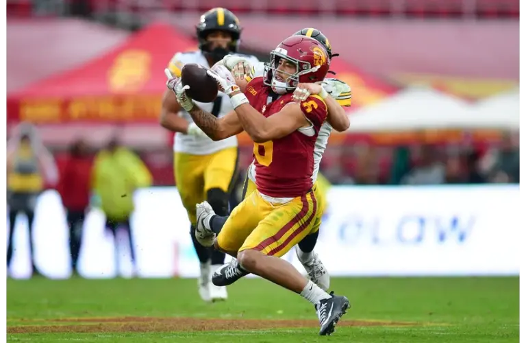 Makai Lemon (6) catches a pass against the defense of Iowa Hawkeyes