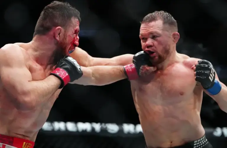 Merab Dvalishvili (red gloves) fights Petr Yan (blue gloves) during UFC 323.