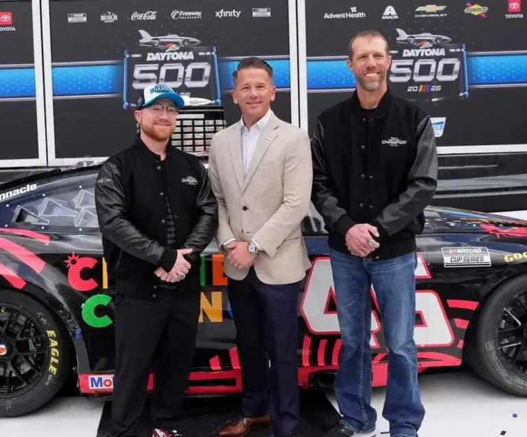 Daytona 500 winner Tyler Reddick (L), Daytona International Speedway President Frank Kelleher and crew chief Billy Scott smile for a photo during the champion ceremony in Victory Lane, Monday, Feb. 16, 2026.