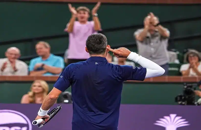 Djokovic cupping his ears infront of the tennis fans