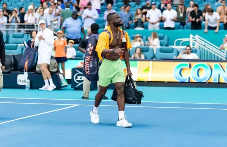 Tiafoe taking his bag off the court