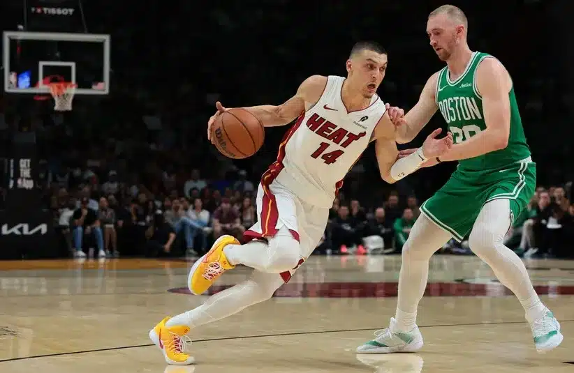Miami Heat guard Tyler Herro (14) drives to the basket against Boston Celtics forward Sam Hauser (30).