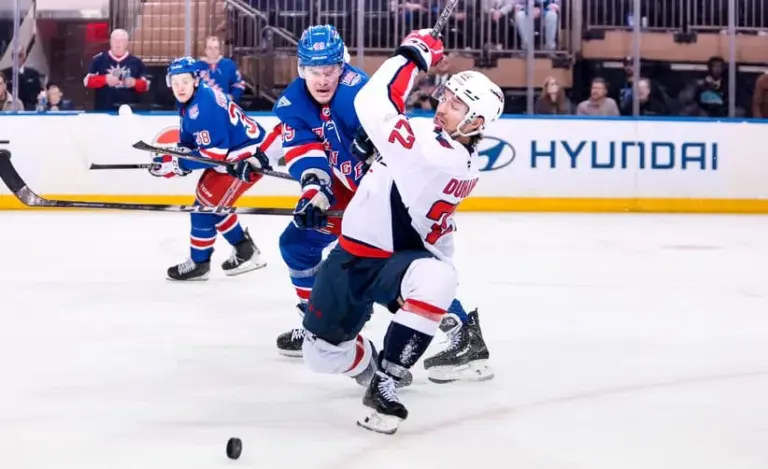 Apr 5, 2026; New York, New York, USA; Washington Capitals left wing Brandon Duhaime (22) is hit by New York Rangers right wing Jaroslav Chmelar (49) during the third period at Madison Square Garden.