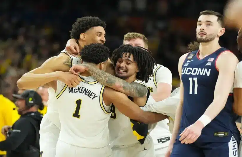 Michigan Wolverines players celebrate after defeating the Connecticut Huskies.