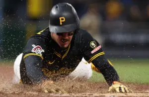 Pittsburgh Pirates shortstop Konnor Griffin (6) slides across home plate.
