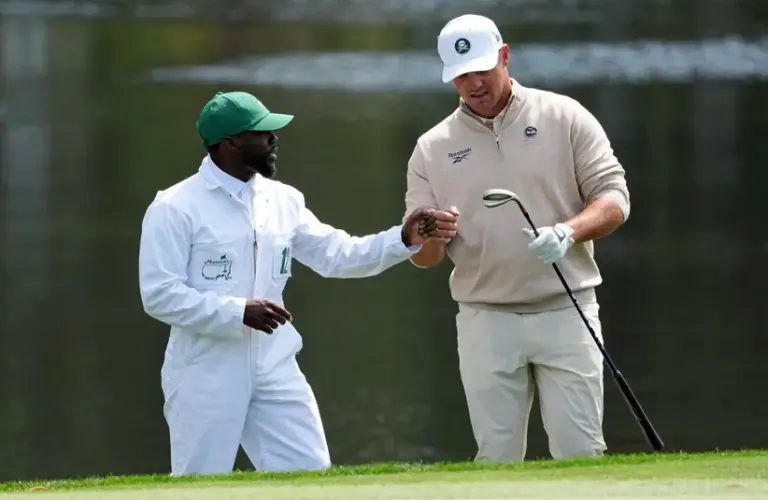 Bryson DeChambeau fist bumps Kevin Hart on the fourth hole during the Par 3 Contest at the Masters Tournament.