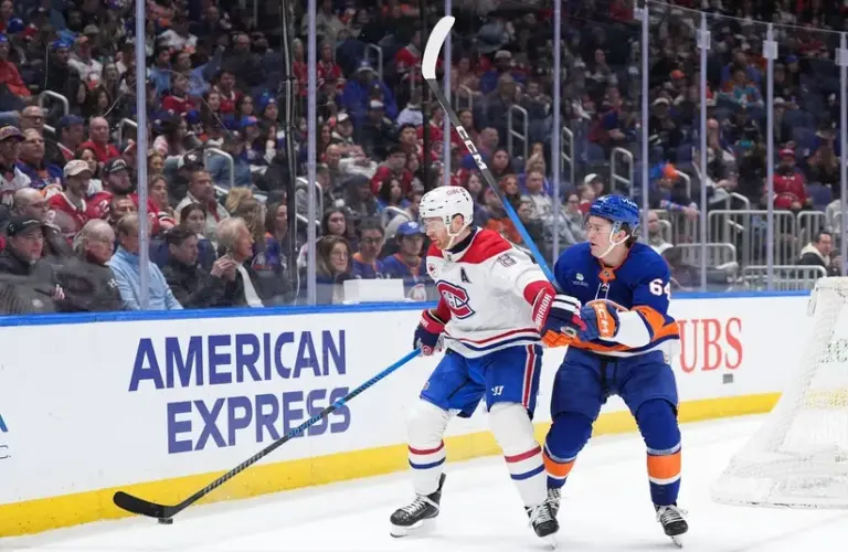 Montréal Canadiens defenseman Mike Matheson (8) fends off a challenge from New York Islanders center Calum Ritchie (64).