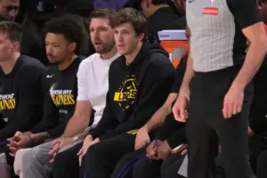 Apr 21, 2026; Los Angeles, California, USA; Los Angeles Lakers guard Luka Doncic (77) and guard Austin Reaves (15) look on from the bench.