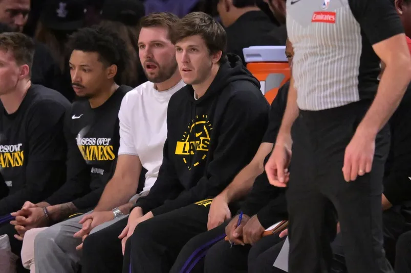 Apr 21, 2026; Los Angeles, California, USA; Los Angeles Lakers guard Luka Doncic (77) and guard Austin Reaves (15) look on from the bench.