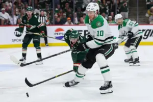 Apr 22, 2026; Saint Paul, Minnesota, USA; Dallas Stars center Oskar Back (10) and Minnesota Wild defenseman Jared Spurgeon (46) compete for the puck during the first overtime period in game three of the first round of the 2026 Stanley Cup Playoffs at Grand Casino Arena.