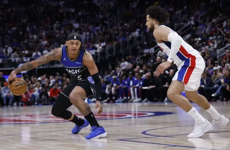 Orlando Magic forward Paolo Banchero (5) dribbles defended by Detroit Pistons guard Cade Cunningham (2)