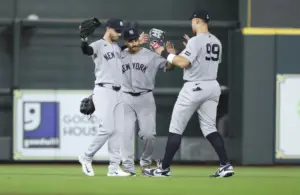 Apr 25, 2026; Houston, Texas, USA; New York Yankees left fielder Cody Bellinger (35) and center fielder Trent Grisham (12) and right fielder Aaron Judge (99) celebrate after the game against the Houston Astros at Daikin Park.