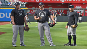 May 26, 2026; Kansas City, Missouri, USA; New York Yankees first baseman Paul Goldschmidt (left), pitcher Gerrit Cole (center) and shortstop Anthony Volpe (right), look on during batting practice, before a game against the Kansas City Royals at Kauffman Stadium.