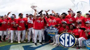 Georgia head coach Wes Johnson hoists the championship trophy as Georgia takes on Arkansas Razorbacks during the SEC baseball tournament championship game at Hoover Metropolitan Stadium in Hoover, Ala. on Sunday, May 24, 2026. Georgia defeated Arkansas 11-1