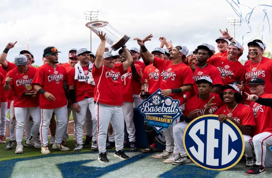 Georgia head coach Wes Johnson hoists the championship trophy as Georgia takes on Arkansas Razorbacks during the SEC baseball tournament championship game at Hoover Metropolitan Stadium in Hoover, Ala. on Sunday, May 24, 2026. Georgia defeated Arkansas 11-1