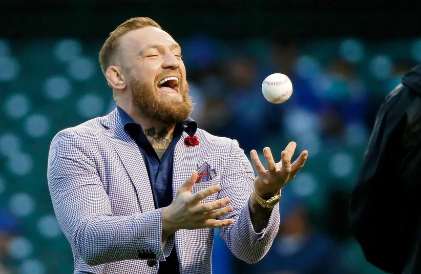 Conor McGregor tosses the ball after throwing out a ceremonial first pitch.