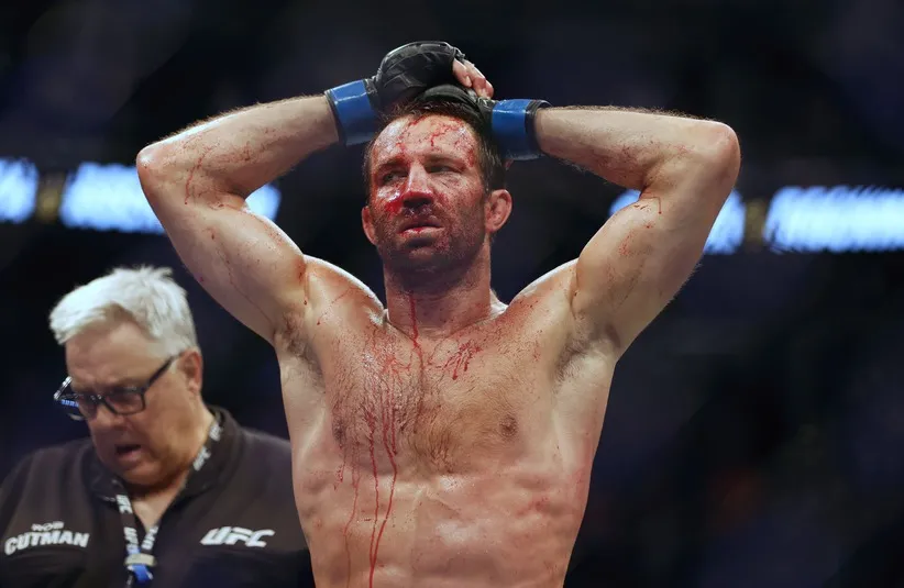 Luke Rockhold (blue gloves) reacts after being defeated by Paulo Costa.