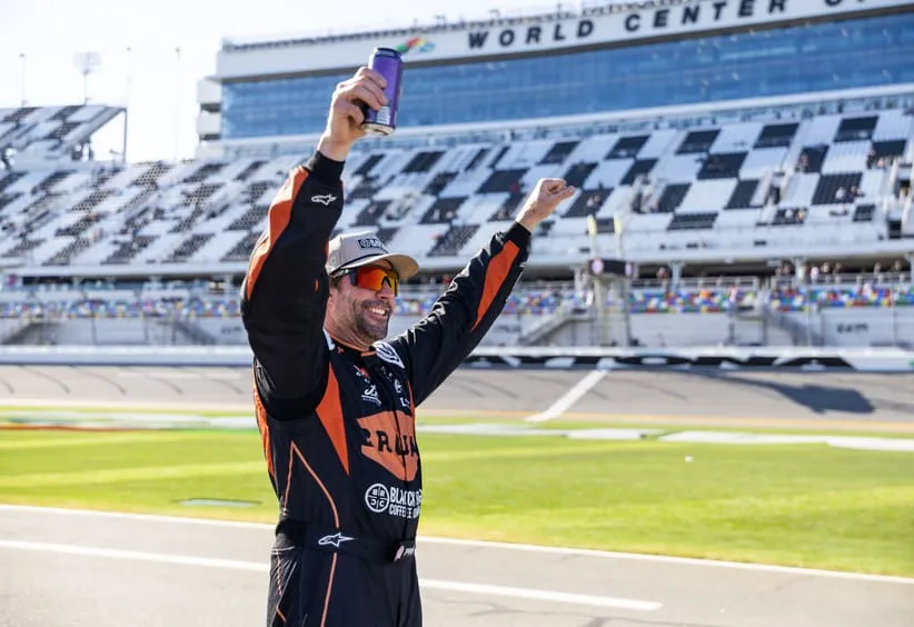 Feb 13, 2026; Daytona Beach, Florida, USA; NASCAR Truck Series driver Travis Pastrana celebrates during qualifying for the Fresh from Florida 250 at Daytona International Speedway.