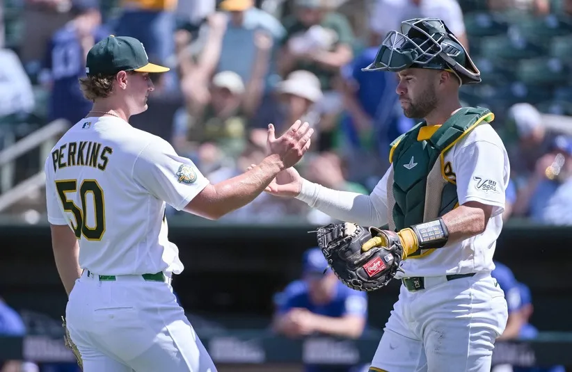 Athletics pitcher Jack Perkins (50) and catcher Austin Wynns (29) celebrate.