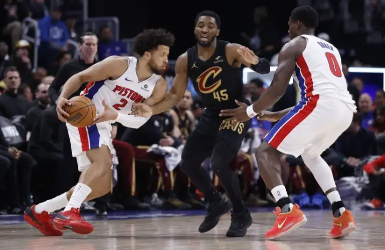 Detroit Pistons guard Cade Cunningham (2) dribbles defended by Cleveland Cavaliers guard Donovan Mitchell (45).