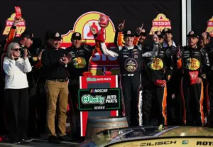 May 9, 2026; Watkins Glen, New York, USA; NASCAR O’Reilly Auto Parts Series driver Connor Zilisch raises the winner’s trophy in victory lane after winning the Mission 200 at Watkins Glen International.