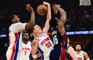 Detroit Pistons forward Duncan Robinson (55) knocks the ball away from Cleveland Cavaliers guard Donovan Mitchell (45).