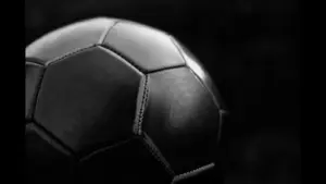 Picture of a soccer ball in black and white with a black background. FIFA has many soccer rules that fans don't know about.