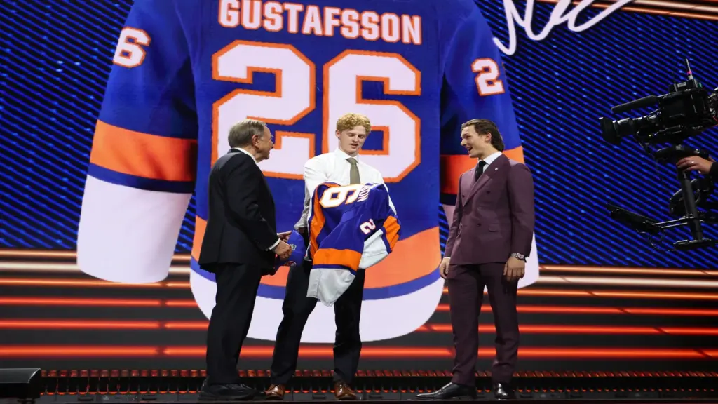 Jun 26, 2026; Buffalo, New York, USA; Malte Gustafsson reacts beside NHL commissioner Gary Bettman and New York Islanders player Matthew Schaefer after being selected with the thirteenth pick in the first round of the 2026 NHL Draft by the Islanders at KeyBank Center.