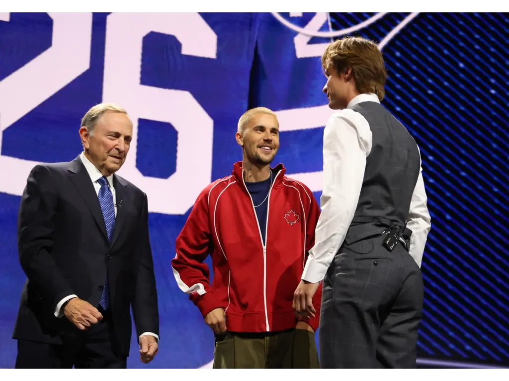 Jun 26, 2026; Buffalo, New York, USA; Gavin McKenna talks to NHL commissioner Gary Bettman and singer Justin Bieber after being selected with the first pick in the first round of the 2026 NHL Draft by the Toronto Maple Leafs at KeyBank Center. Mandatory Credit: Timothy T. Ludwig-Imagn Image