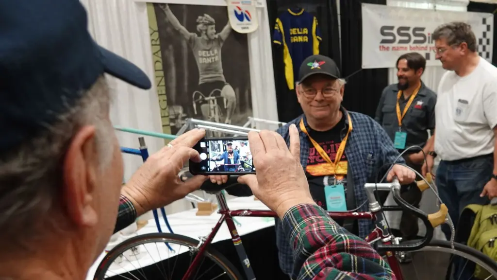 Steel bicycle frame builder Roland Della Santa of Reno, who built frames for three-time Tour de France winner Greg LeMond, poses for a photo in front of one of his frames and a photo of LeMond at the North American Handmade Bicycle Show in March in Sacramento, Calif. Roland Della Santa