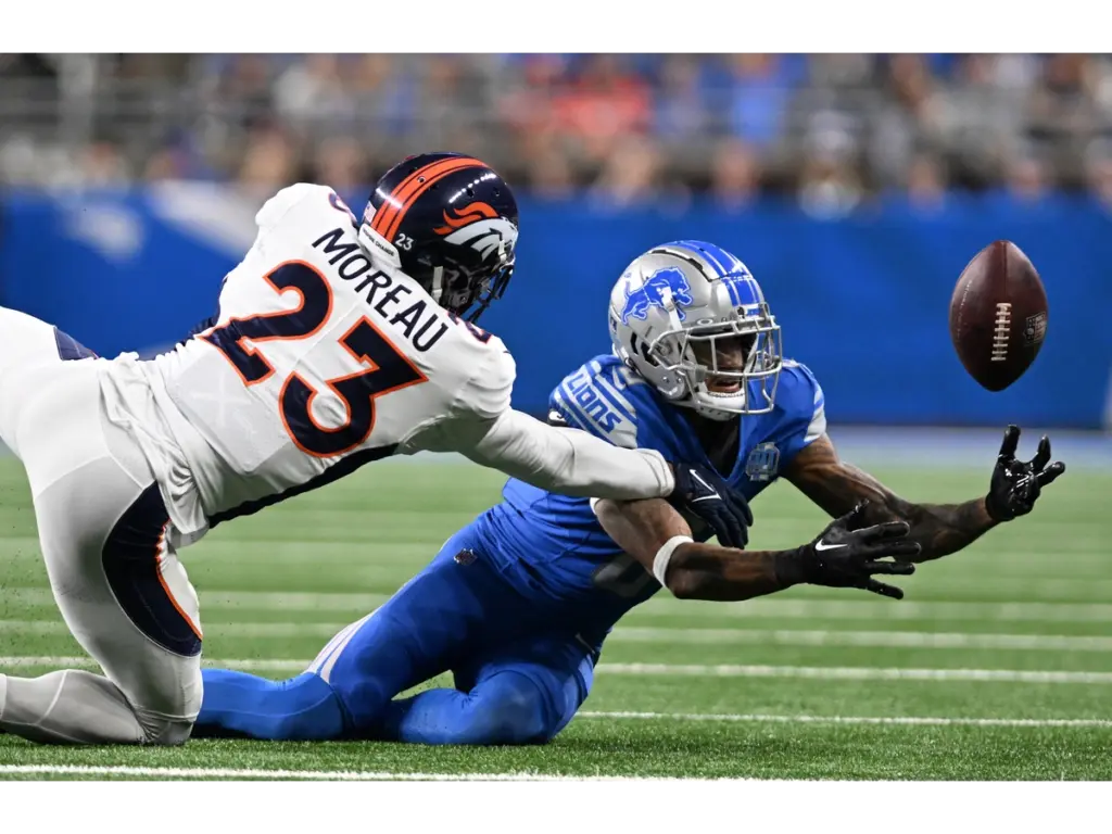 Dec 16, 2023; Detroit, Michigan, USA; Detroit Lions wide receiver Josh Reynolds (8) tries to pull in a pass against Denver Broncos cornerback Fabian Moreau (23) in the fourth quarter at Ford Field. Moreau was flagged for pass interference on the play. Mandatory Credit: Lon Horwedel-USA TODAY Sports