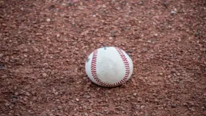 A close-up photograph of a baseball resting on a gravel surface, capturing the texture and detail. This is the instrument of Gerrit Cole's trade with the Yankees.